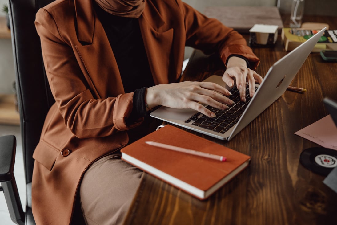 Woman Typing on Laptop in the Office